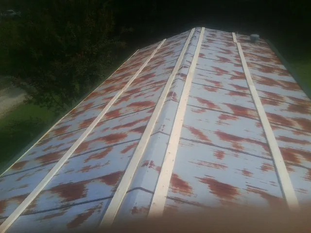 Rusted metal roof panels with new wood purlins before replacement — Storm Damage Roof Repair in Fort Lupton by Roofing Brothers
