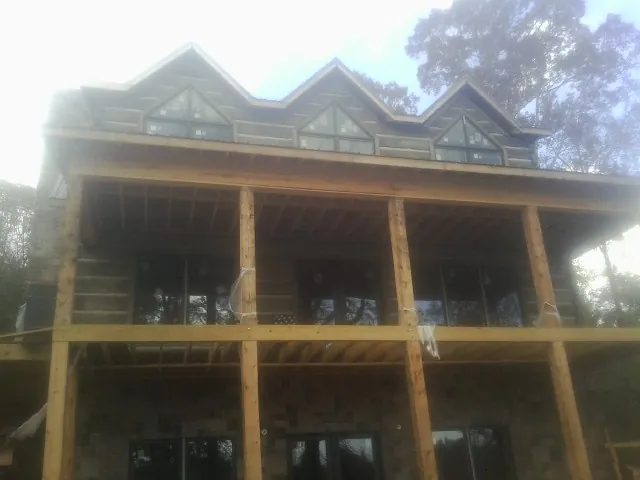 Dormers and porch framing on a large log home under construction — Roof Coating work by our crew in Fort Lupton