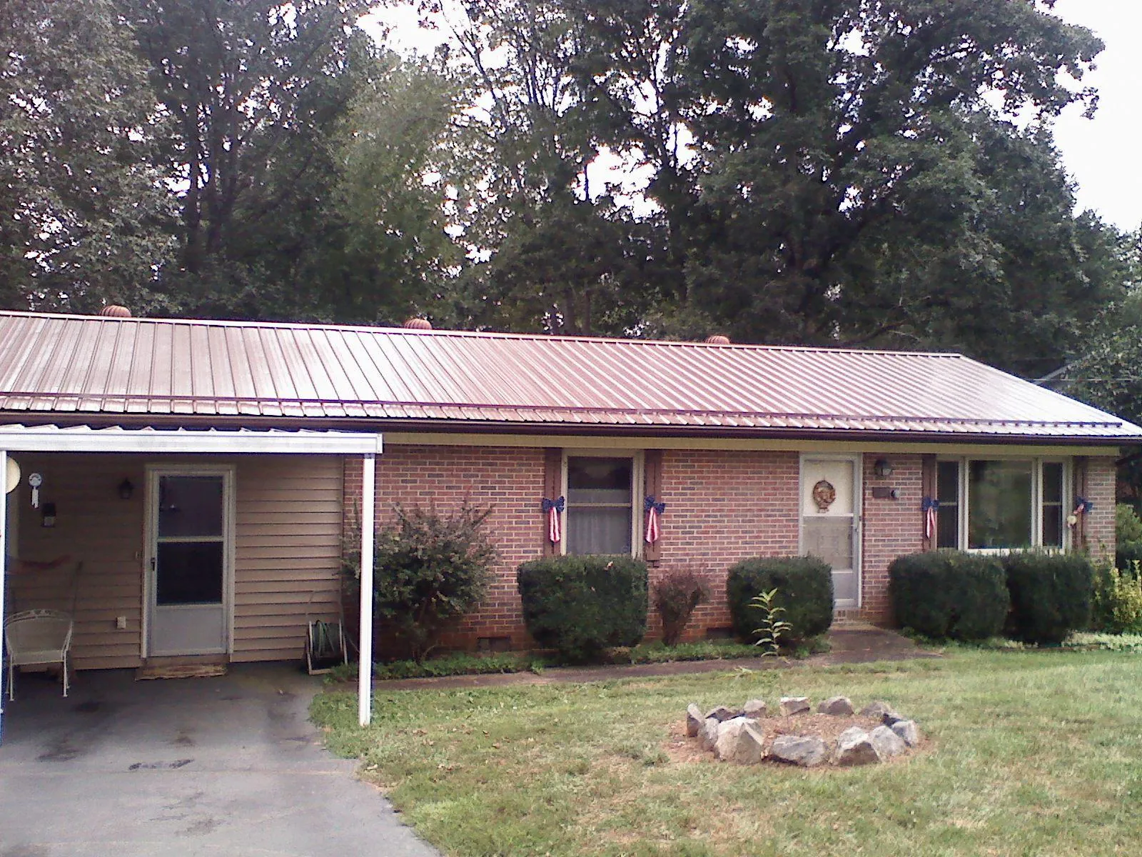 Bronze metal roof and carport on a brick ranch home — Roof Repair work by our crew in Fort Lupton